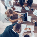 Planning, project management and marketing with business people in meeting for research, strategy and goals with laptop. Growth, analytics and collaboration with employees in corporate office